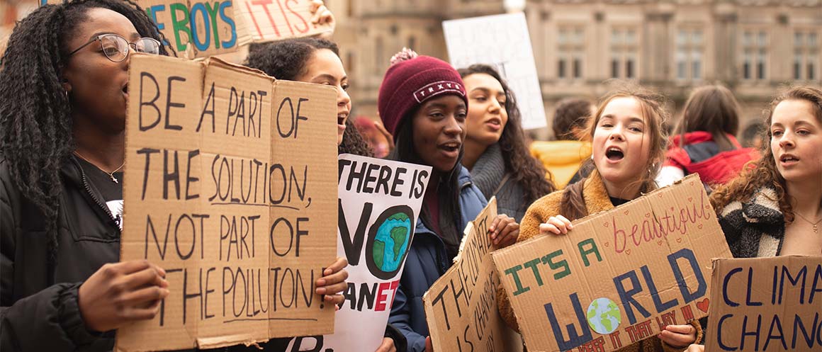 climate campaigners protesting with cardboard signs