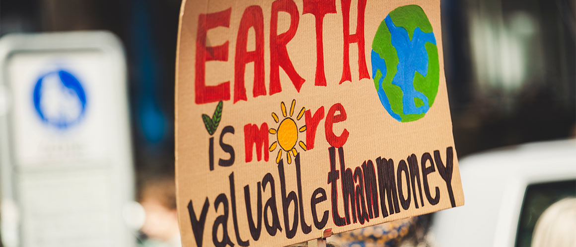 protest placard that reads earth is more valuable than money