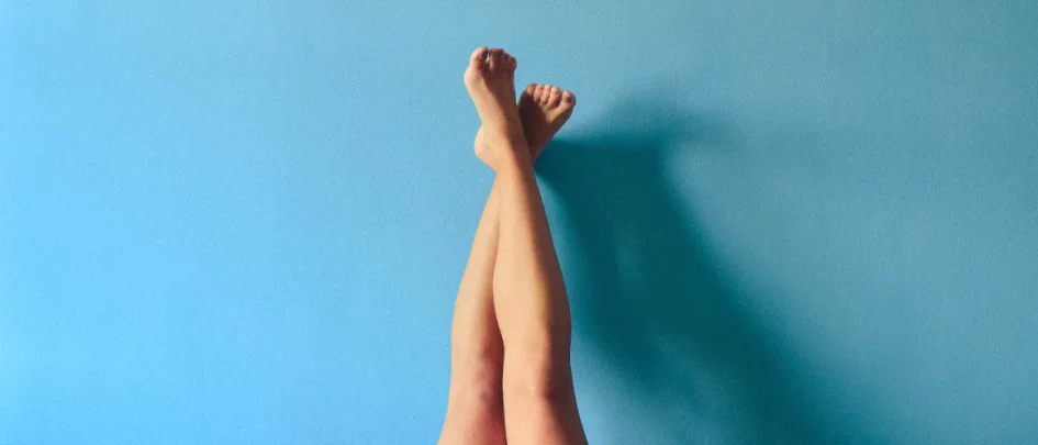 bare legs crossed leaning up a wall